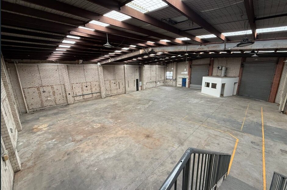 Open warehouse floor with roller doors and mezzanine office at 2 Disney Avenue Keilor East